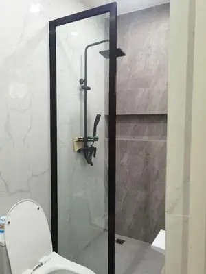 a bathroom with a glass shower with a toilet at Modern 3BR Cozy Homestay Antipolo in Antipolo