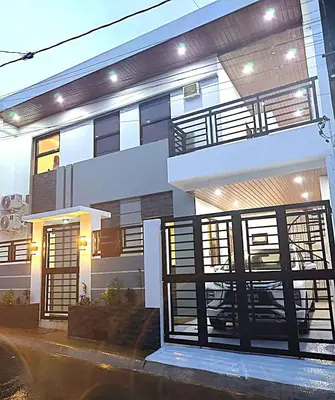 a white house with a balcony and gate at Modern 3BR Cozy Homestay Antipolo in Antipolo