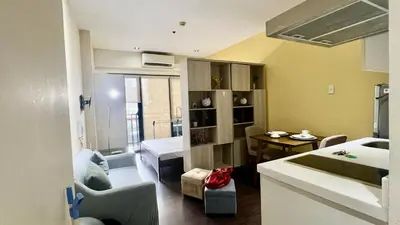 a small room with a bathroom and a bedroom at Cozy Studio Unit at The Knightsbridge Residences in Manila