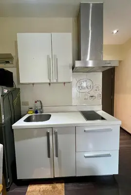 a kitchen with white cabinets and a sink at Cozy Studio Unit at The Knightsbridge Residences in Manila