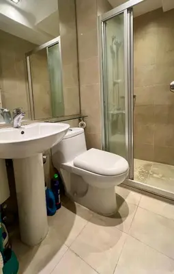 a bathroom with a toilet and a sink and a shower at Cozy Studio Unit at The Knightsbridge Residences in Manila