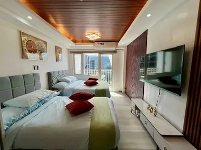a bedroom with two beds and a flat screen tv at Pit Stop Haven Near Manila Airport and Mall of Asia in Manila