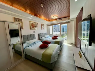 a bedroom with two beds with red pillows at Pit Stop Haven Near Manila Airport and Mall of Asia in Manila