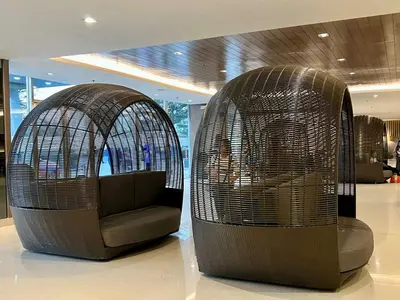 two bird cages with a couch in a building at Pit Stop Haven Near Manila Airport and Mall of Asia in Manila
