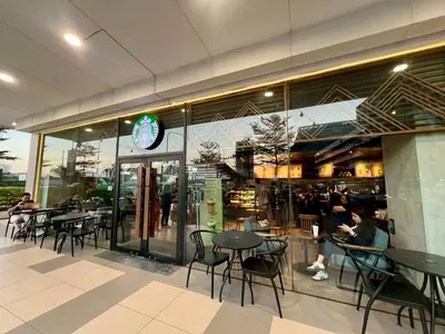 a restaurant with tables and chairs and a clock on the wall at Pit Stop Haven Near Manila Airport and Mall of Asia in Manila