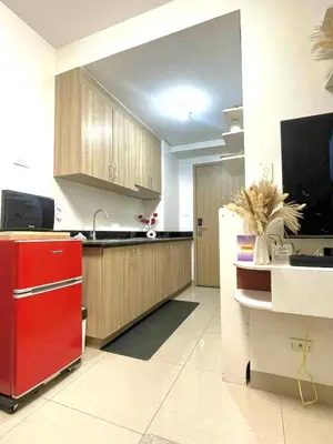 a kitchen with a red refrigerator and wooden cabinets at E&C Rentals in Manila