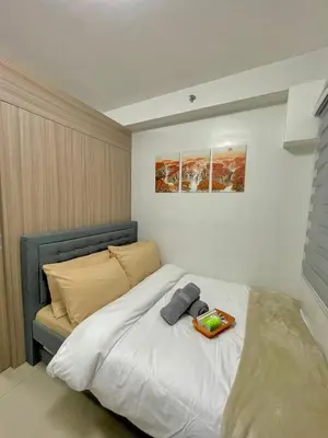 a bedroom with a bed with a tray on it at E&C Rentals in Manila