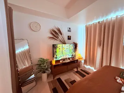 a living room with a flat screen tv on a table at Casa Maria urban resort in Manila