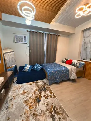 a bedroom with two beds and a couch in it at The Verdin Sweet at Maple Grove Gen Tri Cavite in General Trias