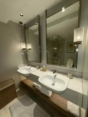 a bathroom with two sinks and a large mirror at Novotel at Acqua, The Hotel Residences by RM in Manila