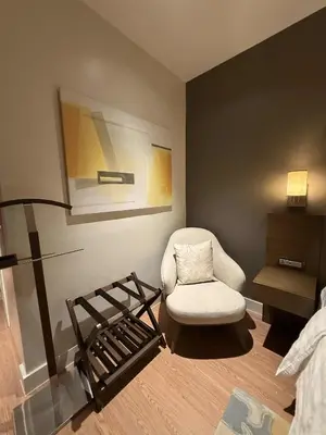 a living room with a chair and a lamp at Novotel at Acqua, The Hotel Residences by RM in Manila