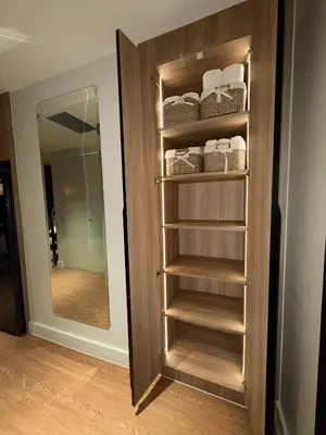 a wooden closet with a mirror and some towels at Novotel at Acqua, The Hotel Residences by RM in Manila
