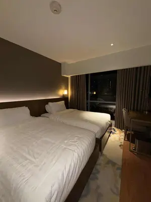 a hotel room with two beds and a window at Novotel at Acqua, The Hotel Residences by RM in Manila