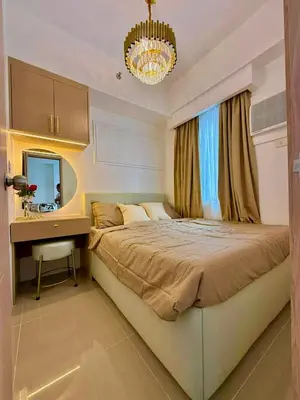 a bedroom with a bed and a desk and a chandelier at Golden Maison de Luxe in Manila