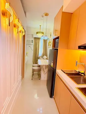 a kitchen with orange walls and a black refrigerator at Golden Maison de Luxe in Manila