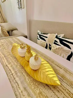 a yellow tray with two cupcakes on a bed at Golden Maison de Luxe in Manila