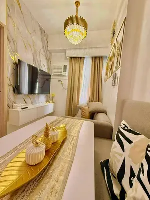 a living room with a table with cakes on it at Golden Maison de Luxe in Manila