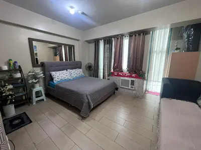 a bedroom with a bed and a living room at Vevilyn Nariz in Manila