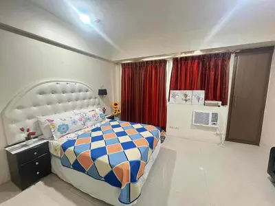 a bedroom with a large bed and red curtains at Vevilyn Nariz in Manila