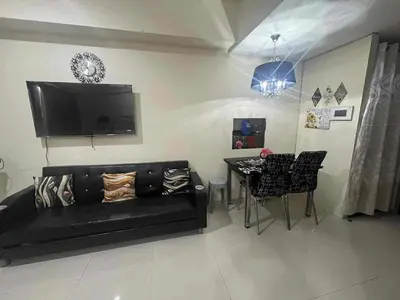 a living room with a black couch and a table at Vevilyn Nariz in Manila