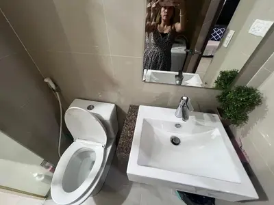 a bathroom with a white toilet and a sink at Vevilyn Nariz in Manila