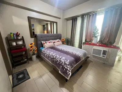 a bedroom with a bed and a mirror at Vevilyn Nariz in Manila