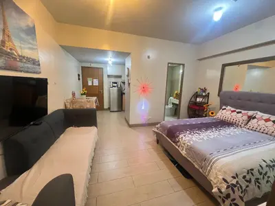a bedroom with a large bed and a large couch at Vevilyn Nariz in Manila