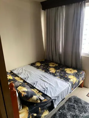 a small bedroom with a bed with a curtain at Maggielyn Jacob Place in Manila