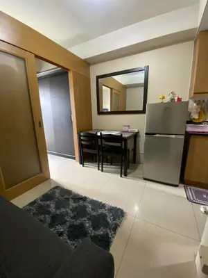 a kitchen with a small table and a refrigerator at Maggielyn Jacob Place in Manila