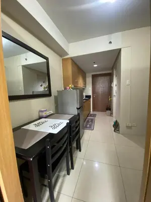 a small kitchen with a table and a refrigerator at Maggielyn Jacob Place in Manila