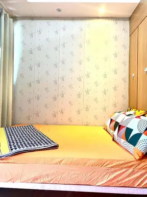 a bedroom with a yellow bed with a window at Maggielyn Jacob Place in Manila
