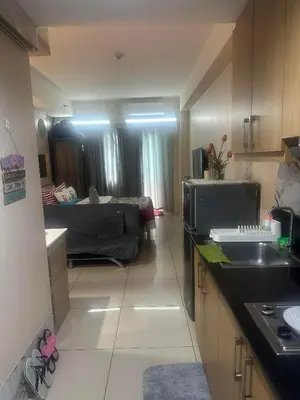 a kitchen with a sink and a living room at Maggielyn Jacob Place in Manila