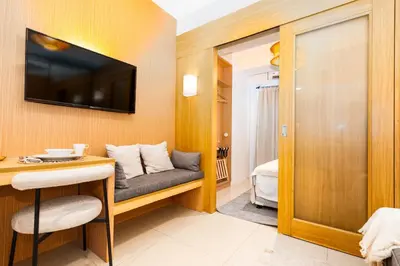 a living room with a couch and a tv at Brand New Japandi - Modern 1 BR Walk to MOA in Manila
