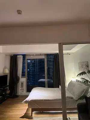 a bedroom with a bed and a large window at Condo near airport - azure residences in Manila