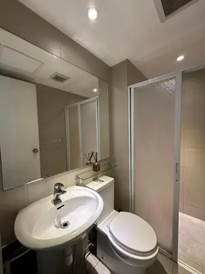 a bathroom with a toilet and a sink and a shower at Condo near airport - azure residences in Manila