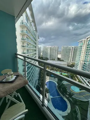 a balcony with a view of a pool and buildings at Condo near airport - azure residences in Manila