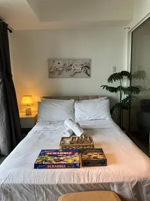 a bed with a tray of food on it at Condo near airport - azure residences in Manila