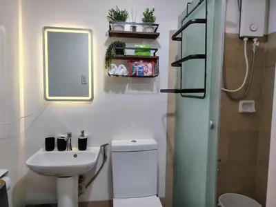 a bathroom with a sink and a toilet and a mirror at NestAway Condo in Manila