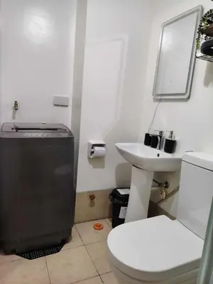 a bathroom with a toilet and a sink at NestAway Condo in Manila