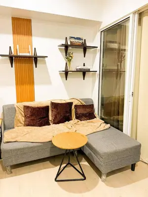 a bedroom with a bed and a table and shelves at Azure 1BR Near NAIA 20 mins Wave Pool in Manila