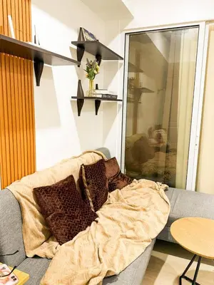 a couch with a blanket on it in a living room at Azure 1BR Near NAIA 20 mins Wave Pool in Manila