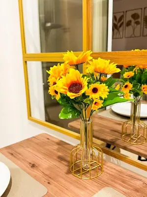 a vase of sunflowers in front of a mirror at Azure 1BR Near NAIA 20 mins Wave Pool in Manila