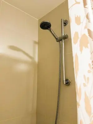 a shower with a shower head in a bathroom at Azure 1BR Near NAIA 20 mins Wave Pool in Manila
