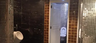 a bathroom with two urinals and a toilet in a stall at Modern Cozy Studio in Makati City with Free Pool, Sauna and Gym in Manila