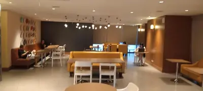 a restaurant with tables and chairs and people sitting at tables at Modern Cozy Studio in Makati City with Free Pool, Sauna and Gym in Manila