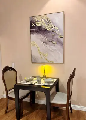 a dining room table with two chairs and a painting at 61F City View at Knightsbridge Makati in Manila