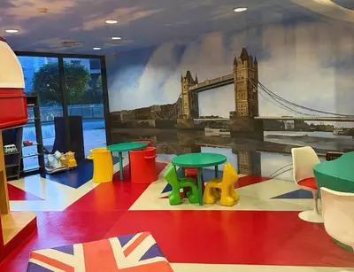a room with tables and a mural of the tower bridge at 61F City View at Knightsbridge Makati in Manila