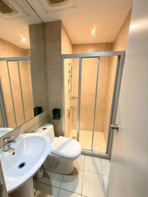 a bathroom with a shower and a toilet and a sink at 61F City View at Knightsbridge Makati in Manila