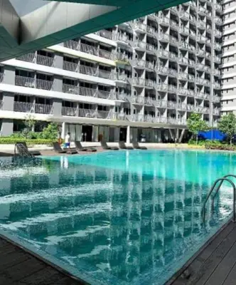 a large swimming pool in front of a building at Garcia's Unit02, SMDC Fame Residences in Manila