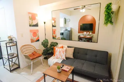 a living room with a couch and a mirror at The Soft Stay 1BR SM Jazz Makati in Manila